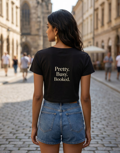 Fourthwave black cropped baby tee with "Pretty. Busy. Booked." text, made of 95% cotton and 5% spandex.