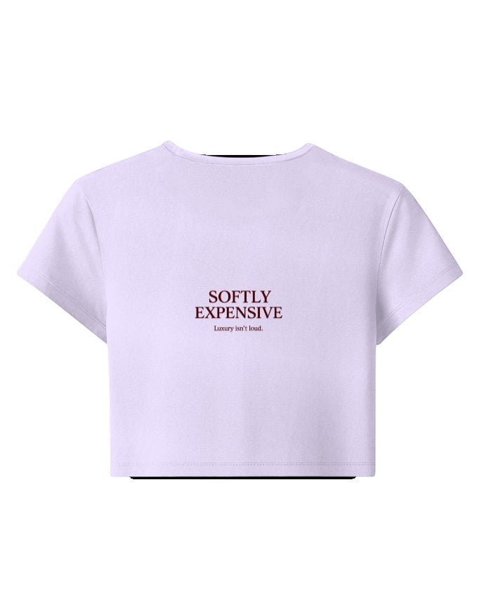 Fourthwave pastel pink cropped t-shirt with crew neck and short sleeves, featuring embroidered text "SOFTLY EXPENSIVE Luxury isn't loud."