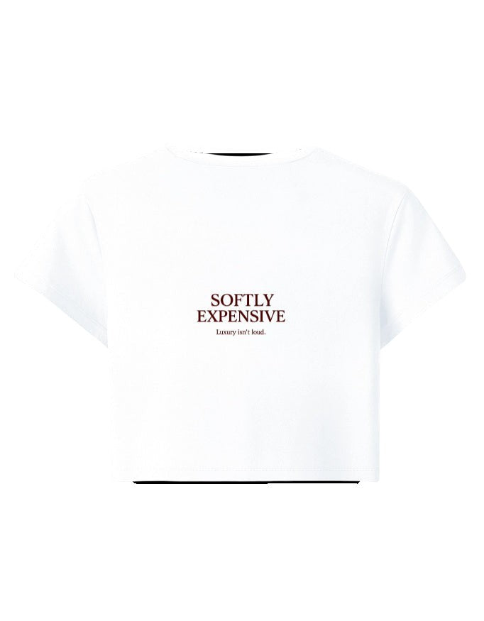 Fourthwave white cropped t-shirt with "SOFTLY EXPENSIVE Luxury isn't loud." text graphic on front. Cotton blend.