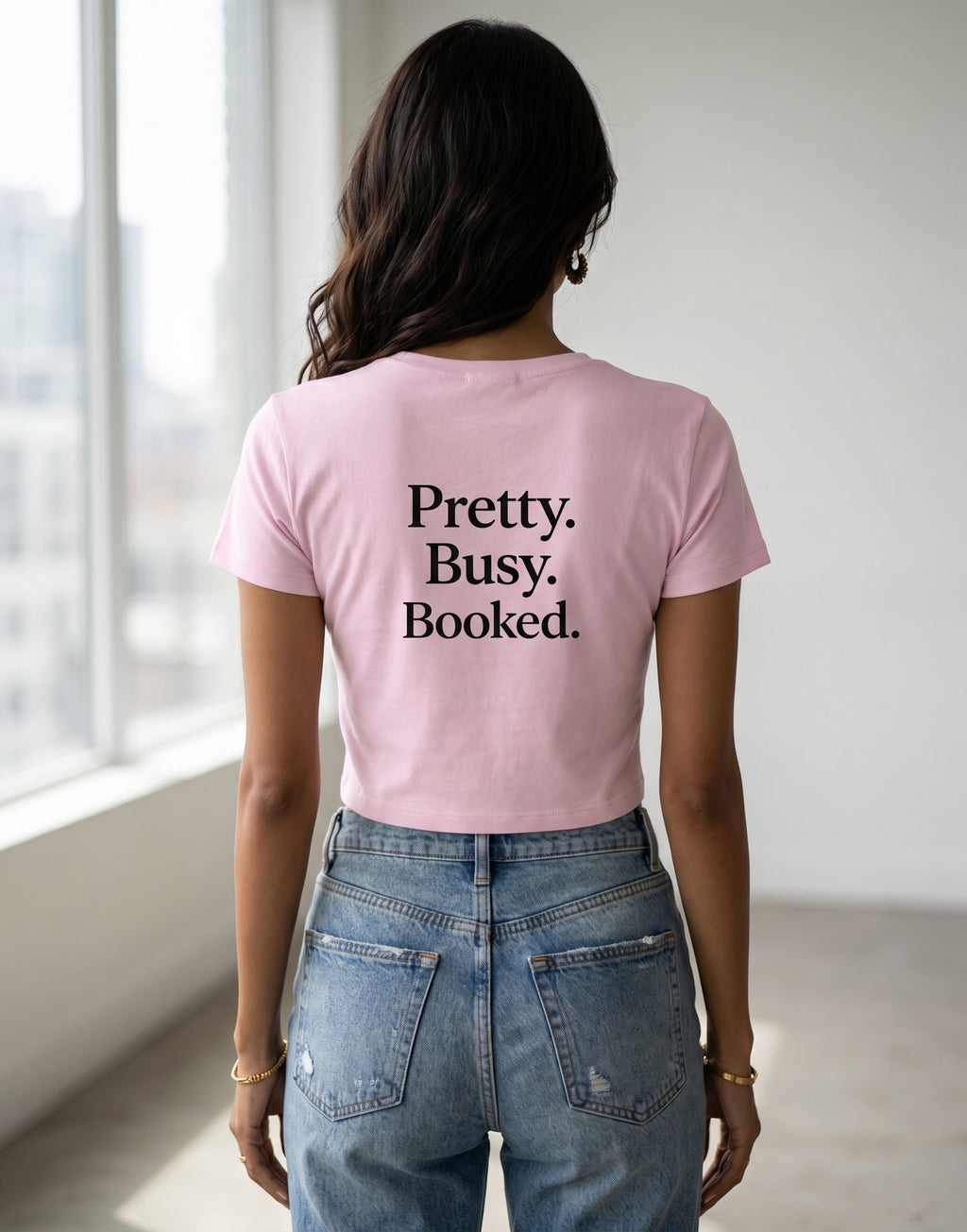 Fourthwave pink baby tee with "Pretty. Busy. Booked." text. Cropped, short-sleeve, 95% cotton, 5% spandex.